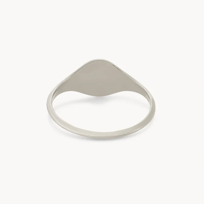 Presenting the Loyalty Signet Ring by bluboho. This minimalist sterling silver ring features a thin band and a smooth, slightly elevated, teardrop-shaped centerpiece. Its simple, elegant design is complemented by a polished finish, perfect against a plain white background. Plus, this ring is engravable for that personal touch.