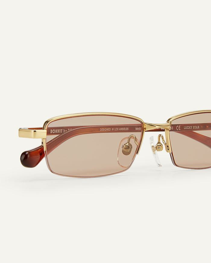 Side shot of Bonnie Clyde Lucky Star sunglasses in gold with brown lenses.