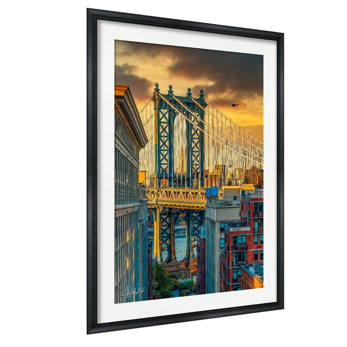 a large suspension bridge with a colorful sunset sky in the background.