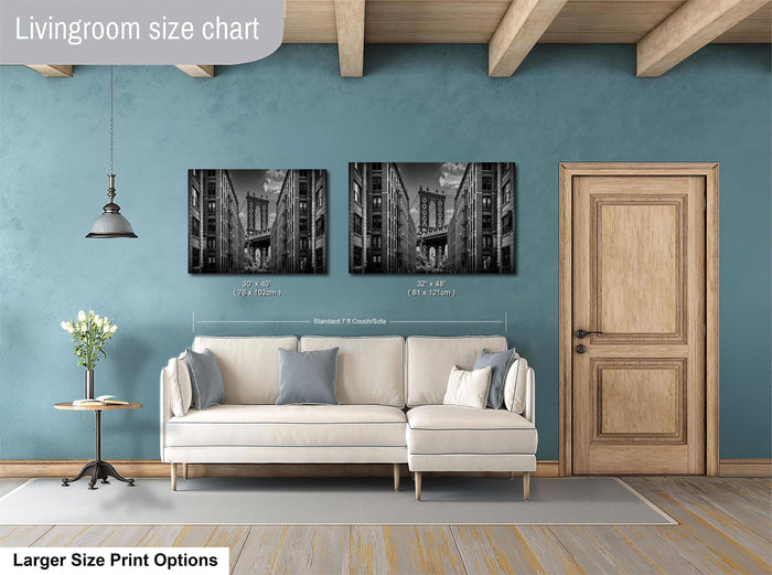a living room with a white sofa, a wooden door, and two framed black and white photographs of a city street.