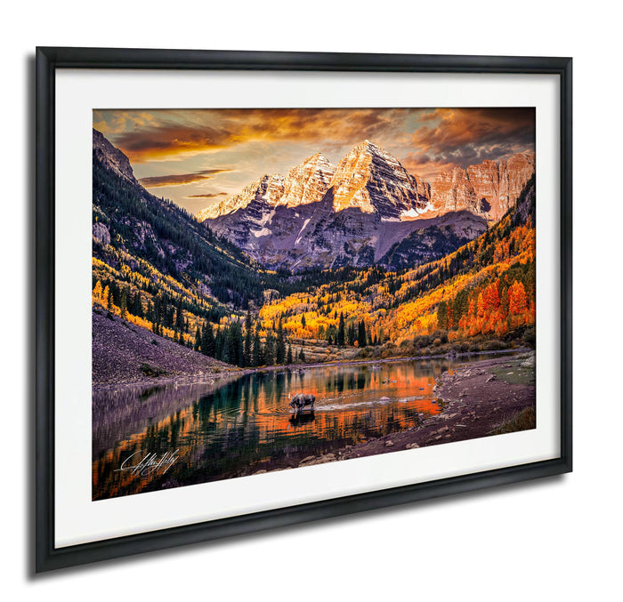a serene mountain landscape with a lake in the foreground, surrounded by trees with autumn foliage. The sky is filled with clouds, creating a dramatic backdrop for the scene.