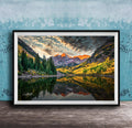 The image is a framed photograph depicting a serene mountain landscape with a lake reflecting the vibrant colors of the sky and surrounding trees.