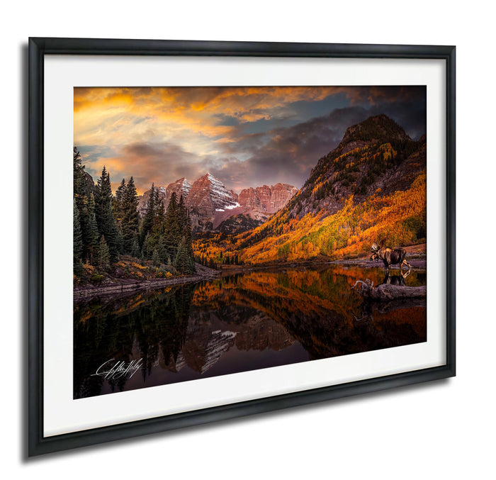 a serene mountain landscape with a lake reflecting the vibrant colors of the sky and surrounding trees.