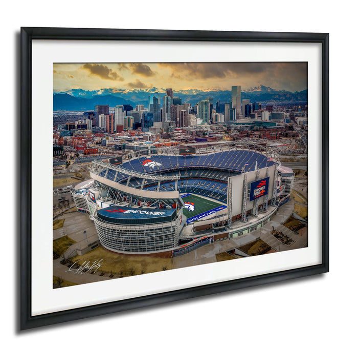 An aerial view of a large sports stadium, likely a football stadium, with the city skyline in the background.