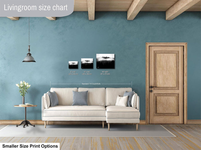 a living room with a white sofa, a wooden door, and a hanging light fixture. There are three framed artworks displayed on the wall, each with different sizes and dimensions. The living room appears to be well-decorated and spacious.