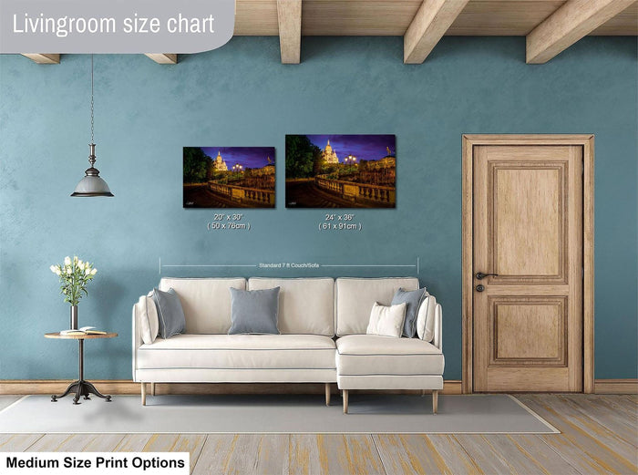 a living room with a white sofa, a wooden door, and a painting of a cityscape on the wall. The living room appears to be well-lit and decorated, with a potted plant and a vase adding to the ambiance.