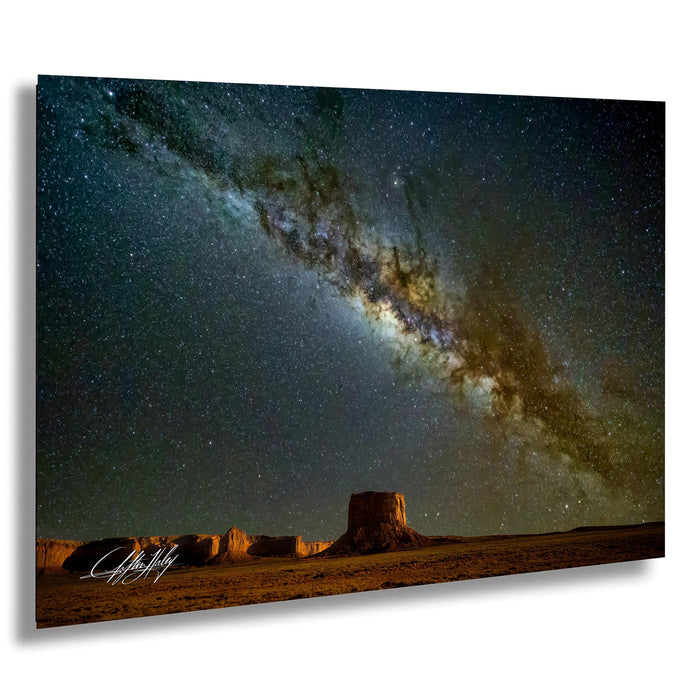 a stunning night sky with a large, bright star in the center, surrounded by a vast expanse of stars and a distant galaxy. The scene is set against a desert landscape with sand dunes and rock formations, creating a serene and awe-inspiring atmosphere.
