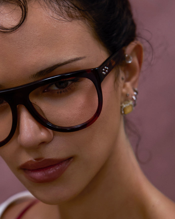 Close-up shot of Bonnie Clyde Moth optical frames in red tortoise with clear lenses.