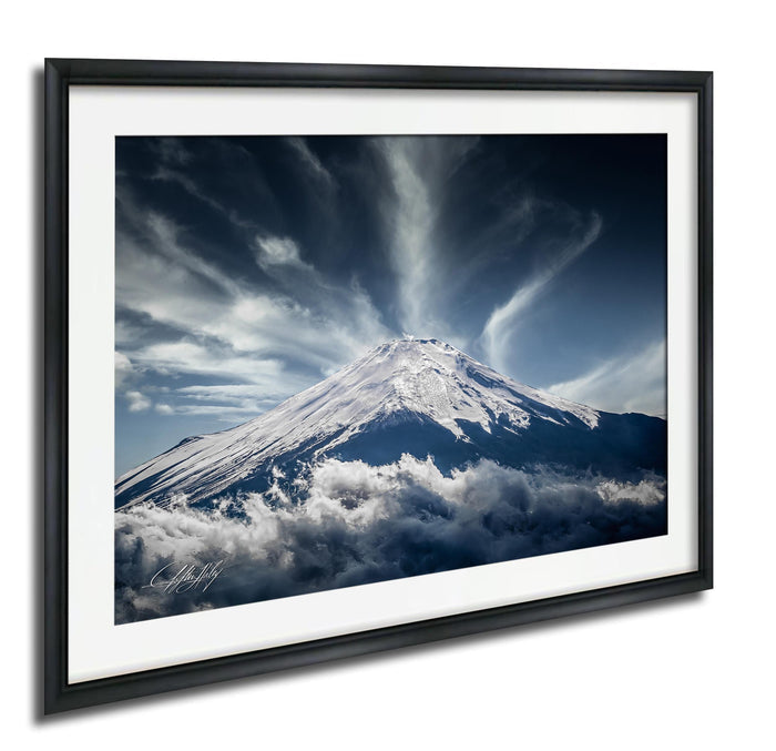 A majestic snow-capped mountain peak emerges from a dramatic cloud formation, creating a striking and awe-inspiring natural landscape.
