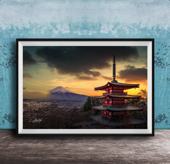 A framed photograph of the Mount Fuji, a famous landmark in Japan, with a red pagoda-style building in the foreground and a dramatic sky in the background.