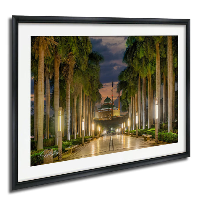 a serene and picturesque scene of a palm-lined pathway leading towards a mosque at night, with the mosque's dome and spire illuminated against a dark sky.