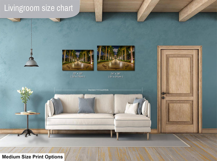 a living room with a white sofa, a wooden door, and a painting of a tropical street scene hanging on the wall.