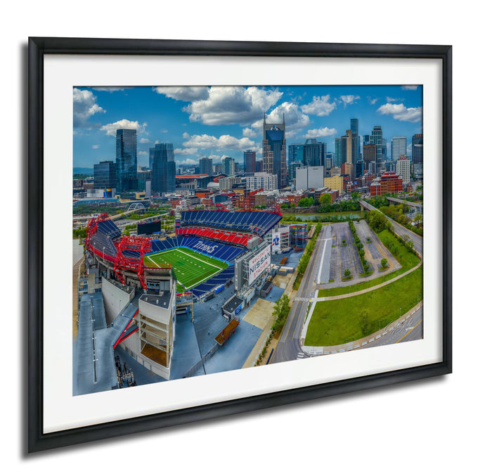 The image is an aerial view of a city skyline with tall buildings and a large sports stadium in the foreground.