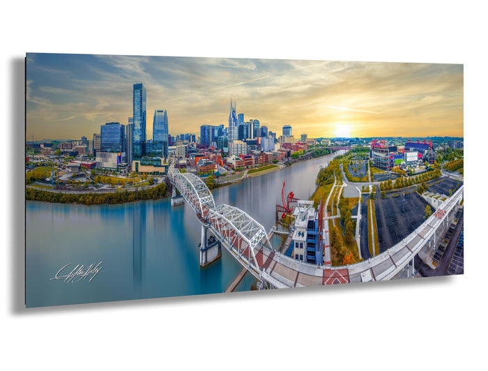 Nashville skyline drone print, aerial view of Cumberland River, Nashville pedestrian bridge wall art, Titans stadium sunset photo, Batman Building skyline print, Music City photography wall decor, Tennessee cityscape metal print, downtown Nashville at golden hour, autumn skyline photo Nashville, faith inspired city wall art, Christian drone photographer print, sunset worship skyline art, modern Nashville wall piece, drone cityscape faith based print, Nashville art for living room