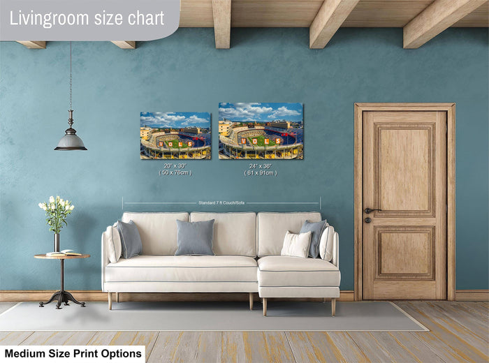 a living room with a white sofa and a wooden door. Above the sofa, there are two framed pictures of a stadium, indicating that the living room is designed for relaxation and entertainment. The living room appears to be well-lit and spacious, with a wooden floor and a ceiling with exposed beams.
