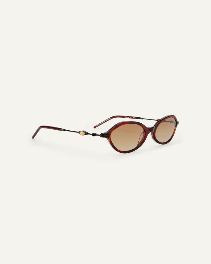 Quarter shot of Bonnie Clyde Nisa sunglasses in black and red tortoise with brown gradient lenses.