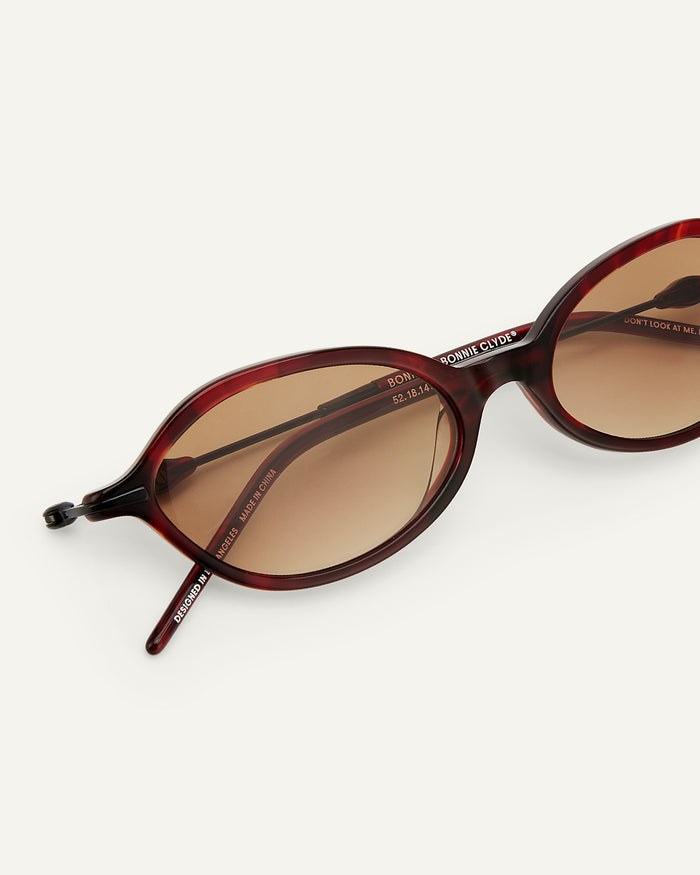 Side shot of Bonnie Clyde Nisa sunglasses in black and red tortoise with brown gradient lenses.