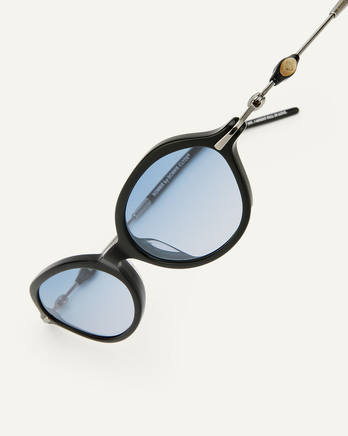 Close-up shot of Bonnie Clyde Nisa sunglasses in black with blue gradient lenses.