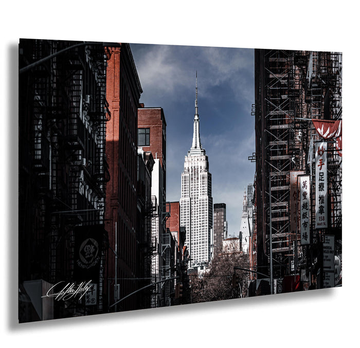A photograph of the iconic Empire State Building in New York City, with the surrounding cityscape and buildings visible in the background.