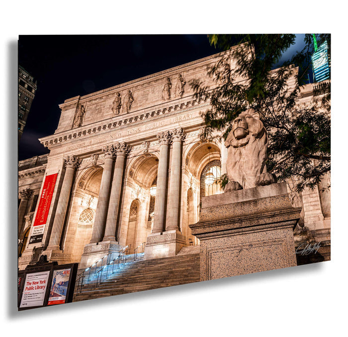a grand, classical-style building with columns and a statue of a lion, illuminated at night.