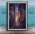 A framed photograph depicting a city street at night, with tall buildings and a bridge in the background. The street is illuminated by streetlights and the glow of the buildings, creating a vibrant and dynamic scene.