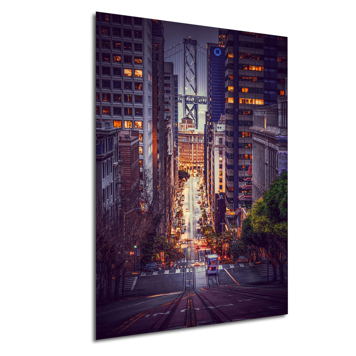 a cityscape at night, with tall buildings illuminated by streetlights and a bridge in the background.