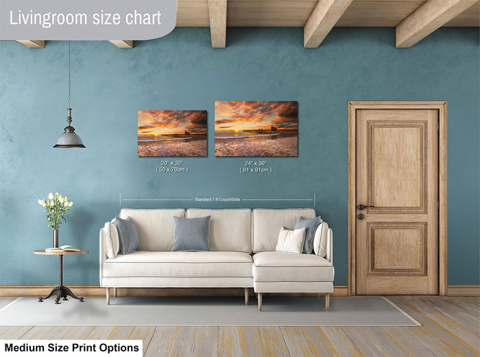 a living room with a white sofa, a wooden door, and a painting of a sunset on the wall. The living room appears to be well-lit and decorated, with a potted plant and a vase adding to the ambiance.