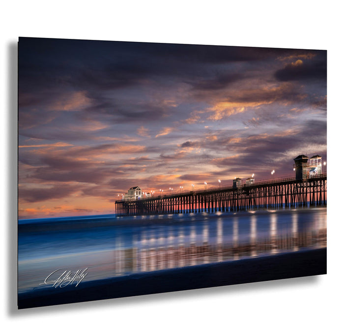 A serene coastal scene at sunset, with a long pier extending into the calm waters. The sky is filled with vibrant hues of orange and pink, creating a stunning backdrop for the pier. The image is a captivating blend of natural beauty and architectural structure, showcasing the harmonious coexistence of nature and human ingenuity.