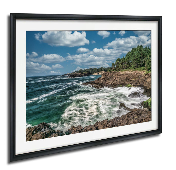 a rocky coastline with crashing waves, surrounded by a blue sky with white clouds.