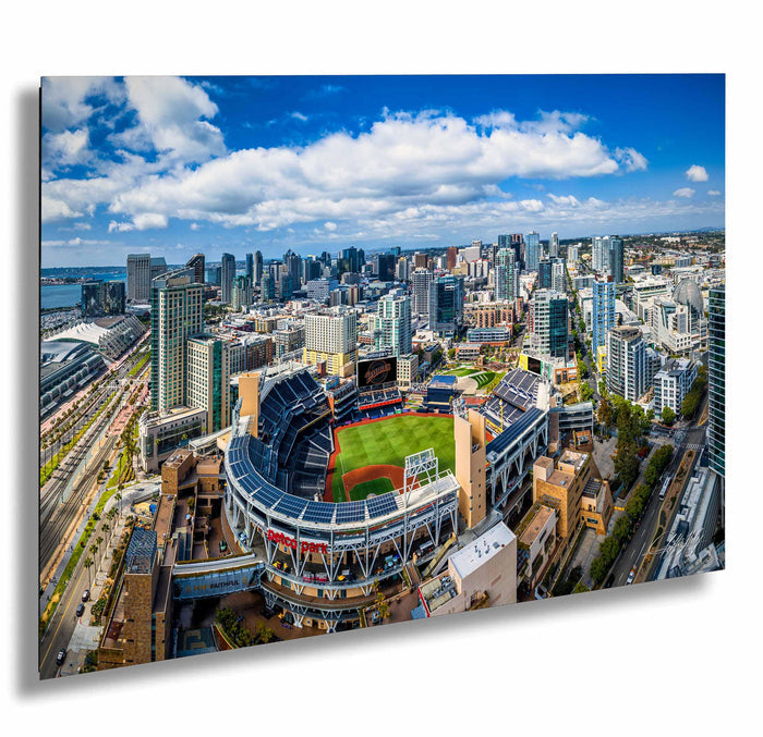 An aerial view of a large baseball stadium surrounded by a city skyline, with tall buildings and skyscrapers in the background.