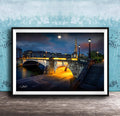 a picturesque night scene of a bridge illuminated by warm lighting, with a full moon in the sky and a tall spire in the background.