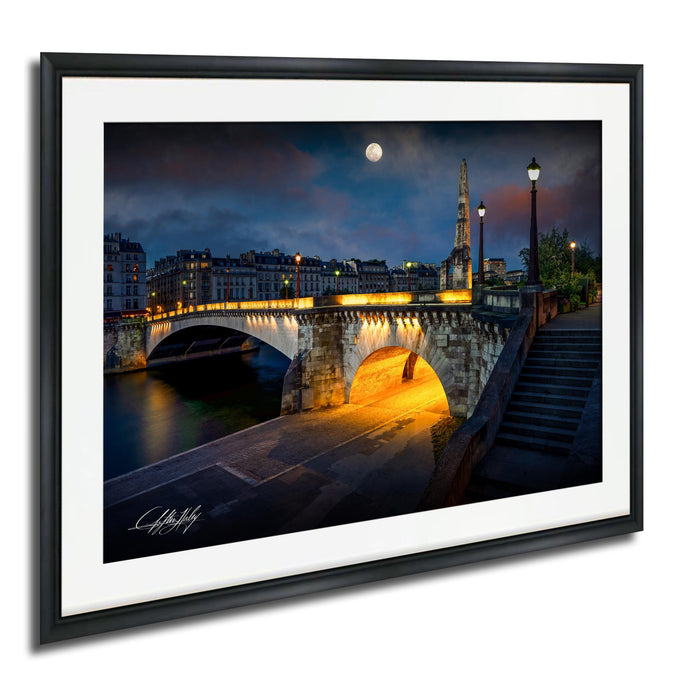 a picturesque night scene of a bridge illuminated by lights, with a full moon in the sky and a tall tower in the background.
