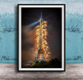 a tall, illuminated tower with a bright light at the top, surrounded by a colorful display of fireworks.