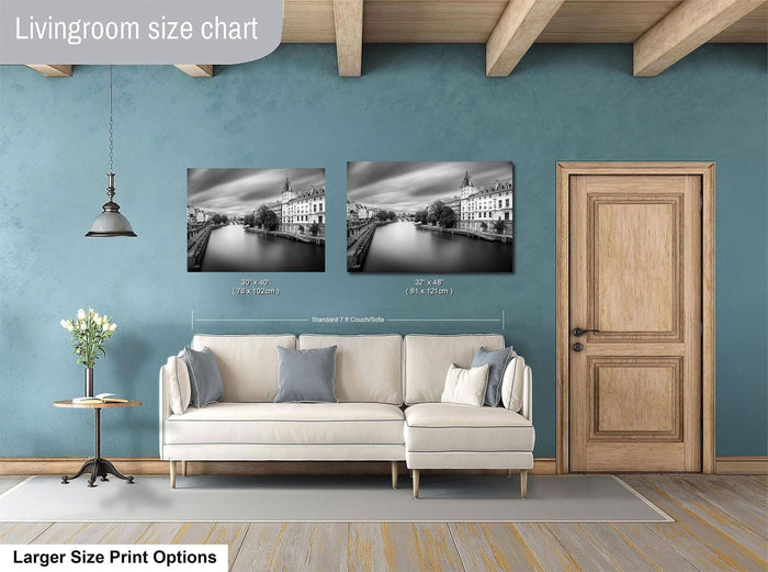 a living room with a white sofa, a wooden door, and a painting of a cityscape on the wall.