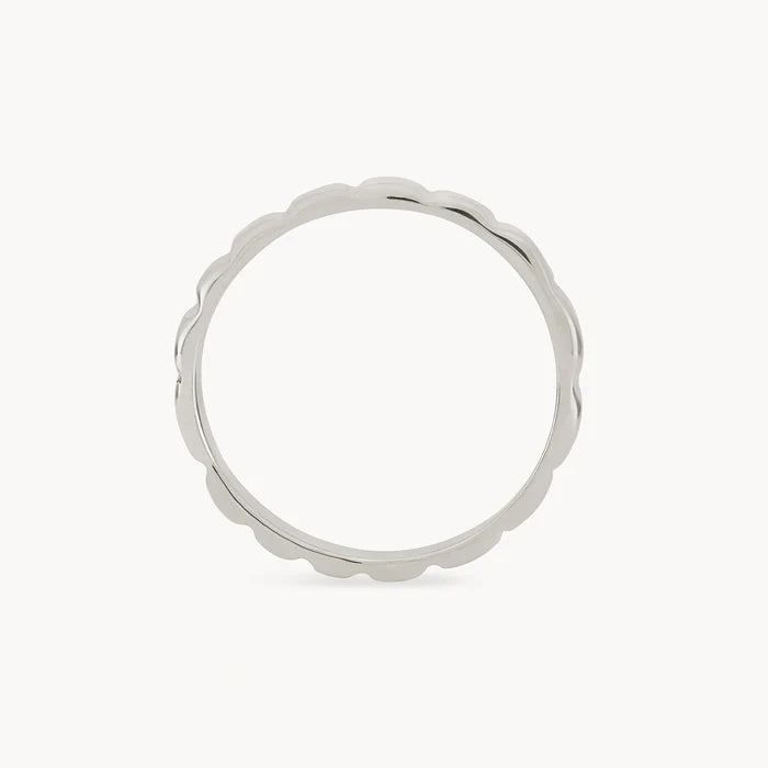 A close-up of the 'peaks and valleys ring - sterling silver' by bluboho, featuring a unique scalloped edge design. The ring is displayed against a plain, white background, highlighting its smooth, reflective surface and the delicate, wavy detail along the outer edge.