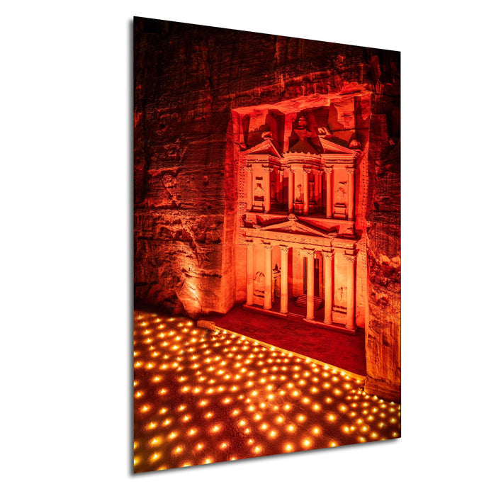 a large, ancient stone structure illuminated by red lights, creating a striking and dramatic scene.