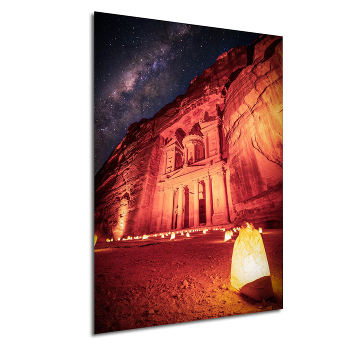 a large, ancient building illuminated by candles, set against a starry night sky.