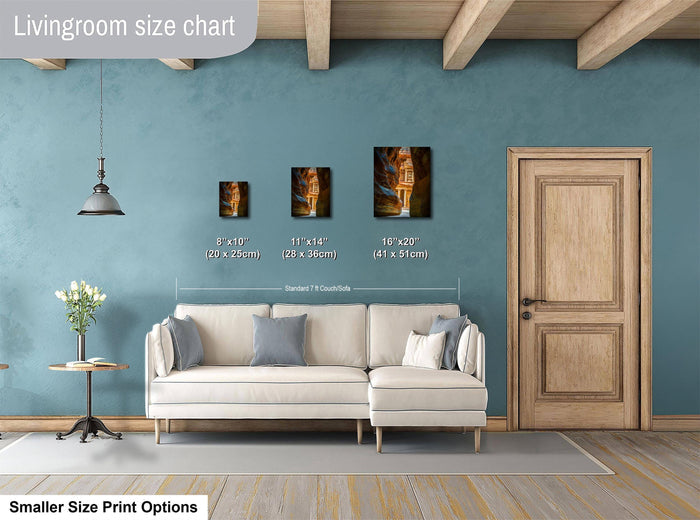 a living room with a white sofa, a wooden door, and a hanging light fixture. There are three framed artworks displayed on the wall, each with a different size and frame. The living room appears to be well-decorated and spacious.