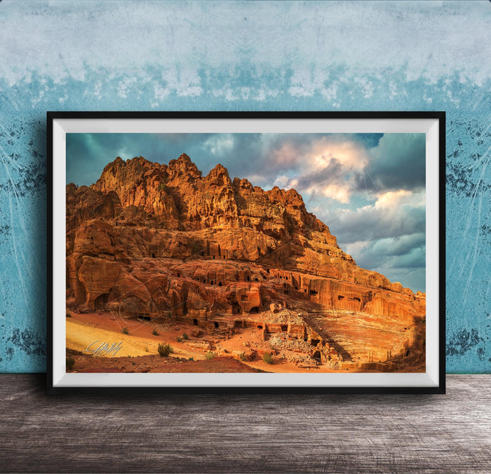 a large, rocky cliff with a dramatic sky in the background.