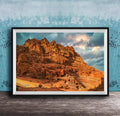 a large, rocky cliff with a dramatic sky in the background.