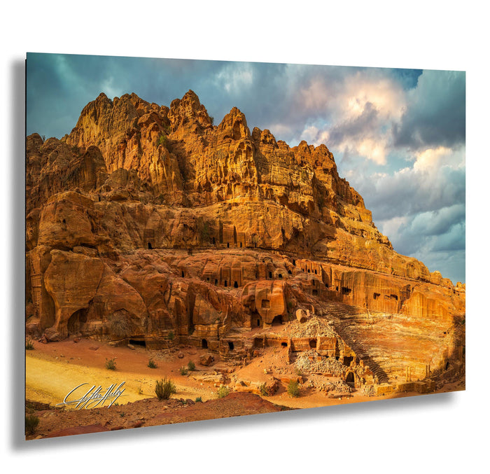 a large, rocky cliff with a dramatic sky in the background.