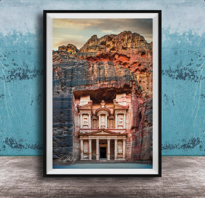 A framed image of the ancient Monastery carved into a cliff face, with a dramatic sky and rocky landscape in the background.