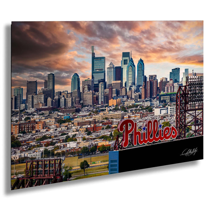 a city skyline with tall buildings and a large sign that says "Phillies" in the foreground.
