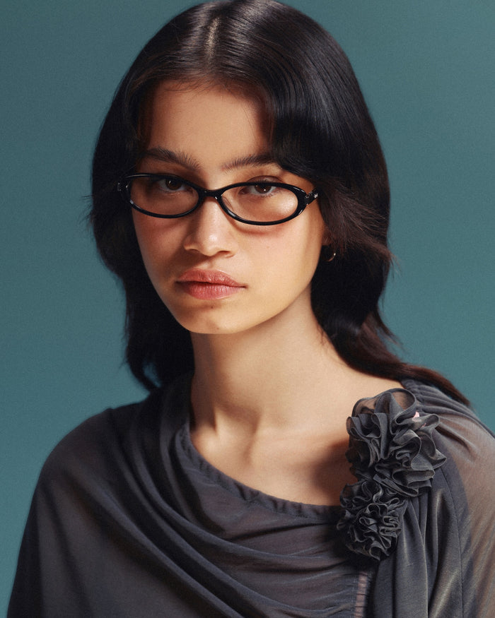 Quarter shot of Bonnie Clyde Pixie optical frames in black with clear lenses.