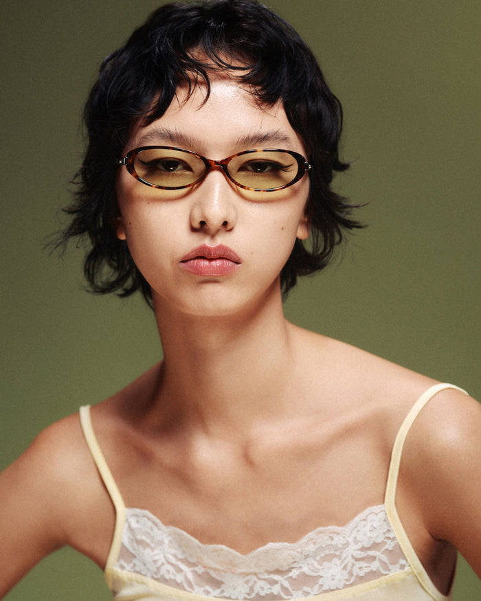 Quarter shot of Bonnie Clyde Pixie sunglasses in tortoise with green lenses.