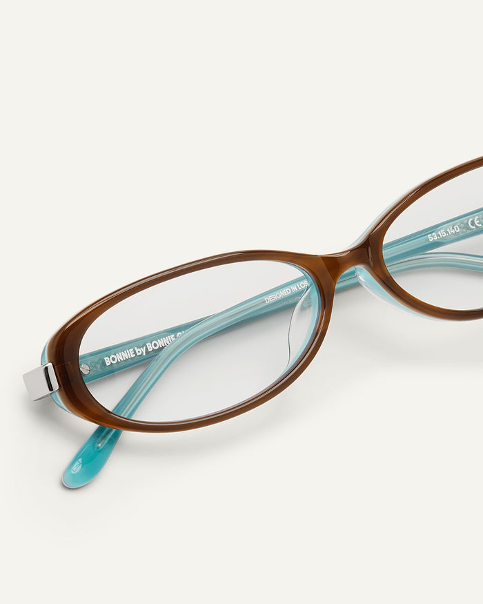 Close-up shot of Bonnie Clyde Pixie optical frames in layered teal demi with clear lenses.