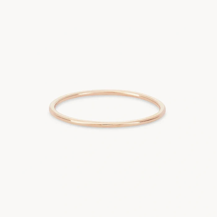 A delicate, thin 10k yellow gold ring from bluboho's plain jane stacking ring collection is shown against a plain white background. The ring has a simple, minimalist design with a smooth surface and a circular shape.