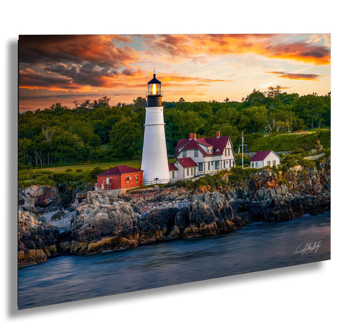 A picturesque lighthouse stands on a rocky cliff overlooking a serene body of water, with a stunning sunset sky in the background.