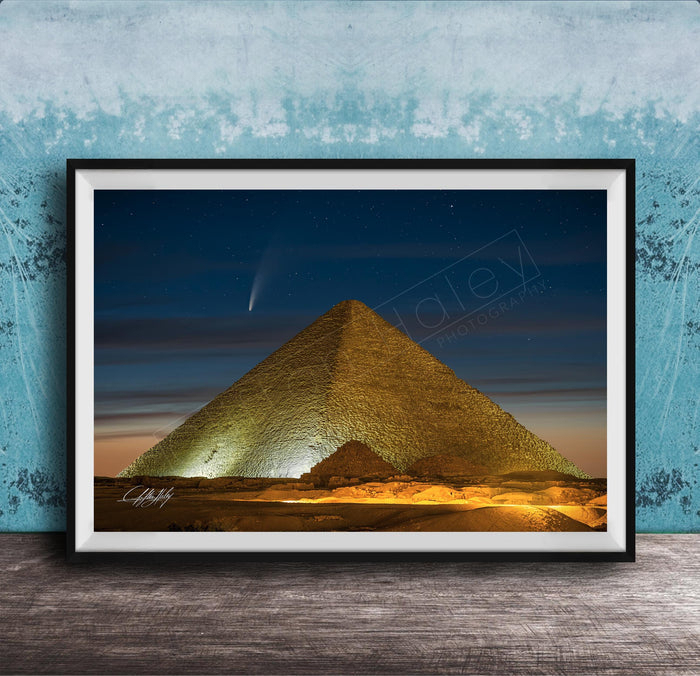A framed photograph of the Great Pyramid of Giza at night, with a bright star visible in the sky above the pyramid.