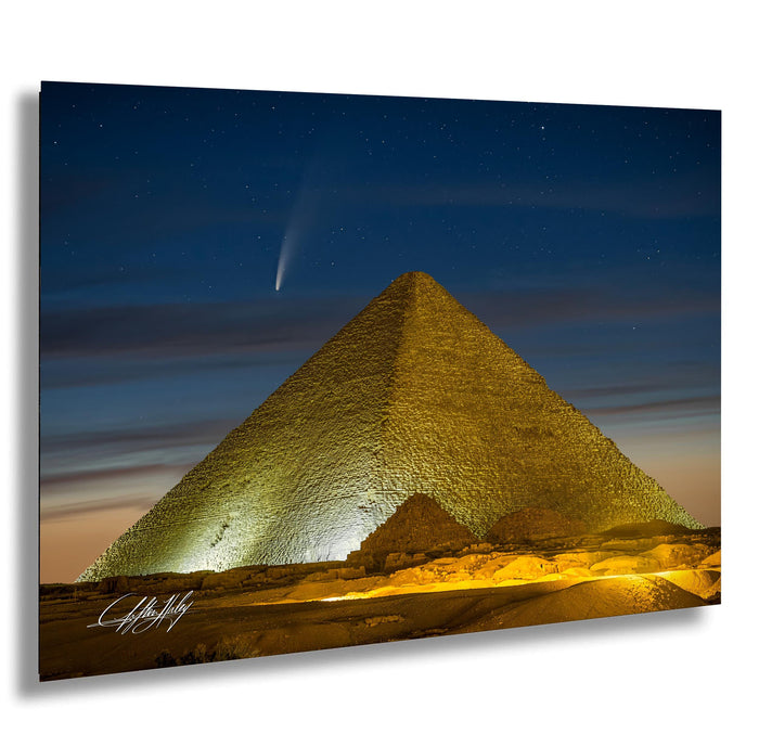 a large pyramid illuminated at night, with a bright star visible in the sky above it.